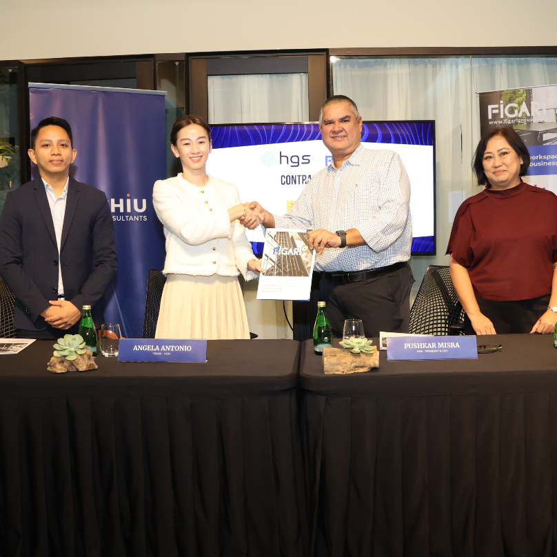 Figari and HGS executives shaking hands after signing a business contract